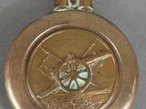 a gold medal with a picture of a man holding a baseball bat