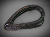 an old leather belt with a metal buckle on a gray surface