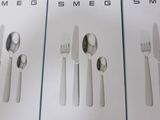 three boxes of silverware sitting on top of a white table