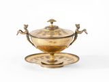 un plateau en or sur lequel sont posés une tasse et une soucoupe