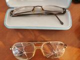a pair of glasses sitting on a table next to a pair of glasses