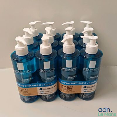 quatre flacons de gel hydroalcoolique sont alignés sur un comptoir