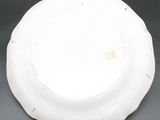a white plate with a gold rim sitting on a table