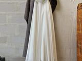 a white dress hanging on a clothes rack in a room