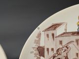 two plates with a picture of a man holding a sword