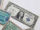 several different bills of different colors and shapes on a white surface