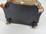 a black suitcase with gold trim and wheels on a white surface