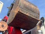 a red truck with a large wooden barrel on the back of it