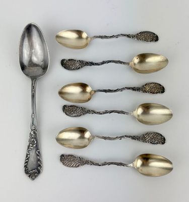 five spoons and two spoons on a white surface