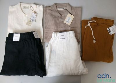 Quatre paires de vêtements pour hommes sont disposées sur une table