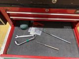 a red tool box with tools in it on the floor