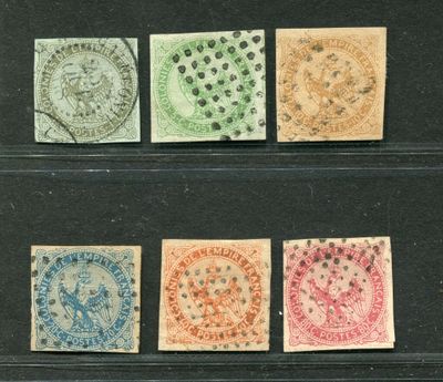 four different colored stamps on a black surface
