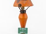 an orange table lamp with a green card attached to it