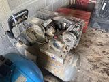 two air compressors sitting next to each other on the ground