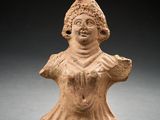 une petite figurine en argile représentant une femme coiffée d'un chapeau