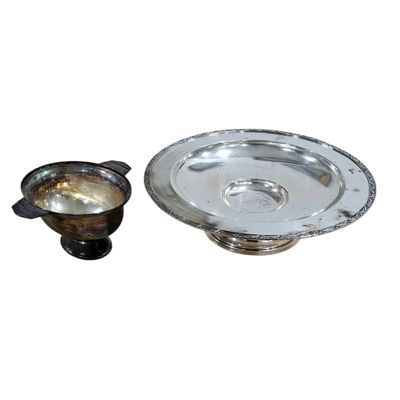 a silver plate and a silver cup next to each other