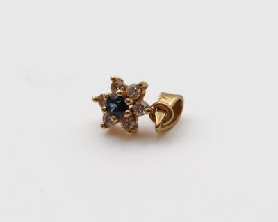 une image représentant une boucle d'oreille en or sertie de diamants bleus et blancs