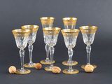 six verres à vin aux bords dorés et ornés de bouchons, sur fond noir