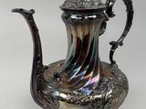 silver plated tea pot with a bird on top of it