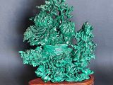 a green statue of a boat on a wooden stand