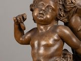 an antique bronze statue of a boy and a girl holding a baby