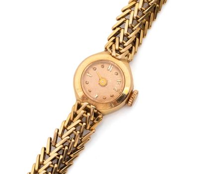 une photo d'une montre-bracelet pour femme montée sur un bracelet en or