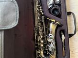 un saxophone dans son étui, posé sur un plancher en bois
