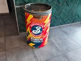 une canette de soda posée par terre devant une porte