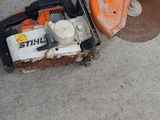 a chainsaw that is sitting on the ground next to a wall