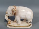 porcelain figurine of an elephant holding a flower in its trunk