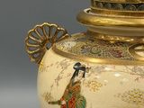 a vase with a lid that has a bird on it