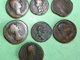six ancient roman coins on a green surface