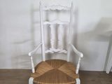 a white chair with a wooden seat on a wooden floor