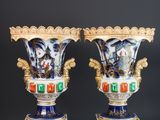 paire de vases bleus et blancs ornés de motifs dorés, posés sur des socles