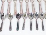 a lot of spoons and forks on the table