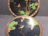 two plates with birds and flowers on them on a table