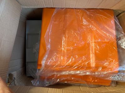 a large orange piece of luggage in a box