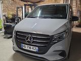 Le monospace Mercedes est garé dans le garage de la maison.