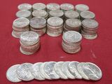 a pile of silver coins sitting on a red surface