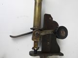 a wall mounted microscope on a white wall next to other objects