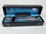 a silverware in a case with a spoon and spoon rest