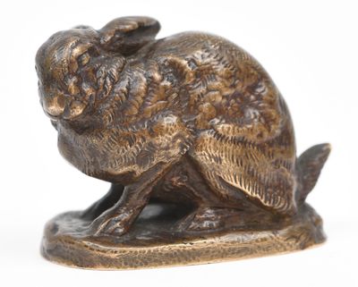 a bronze statue of a rabbit on a white background