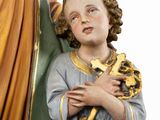 a statue of an angel holding a cross and a book