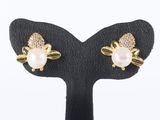 a pair of pearl and gold earrings on a black stand