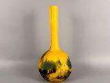 a yellow vase with a black and yellow design on it