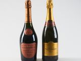two bottles of champagne sitting next to each other on a white surface