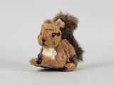un petit écureuil en peluche assis par terre