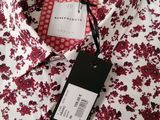 a close up of a red and white shirt with a tag on it