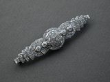 an image of a silver broochle with a bunch of diamonds on it