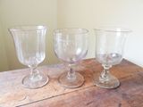 trois verres à vin vides posés sur une table en bois